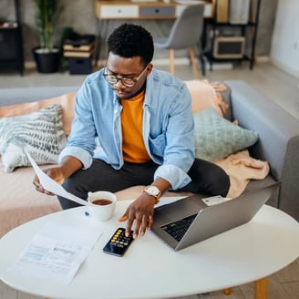 Man reviewing loan options with paper and calculator