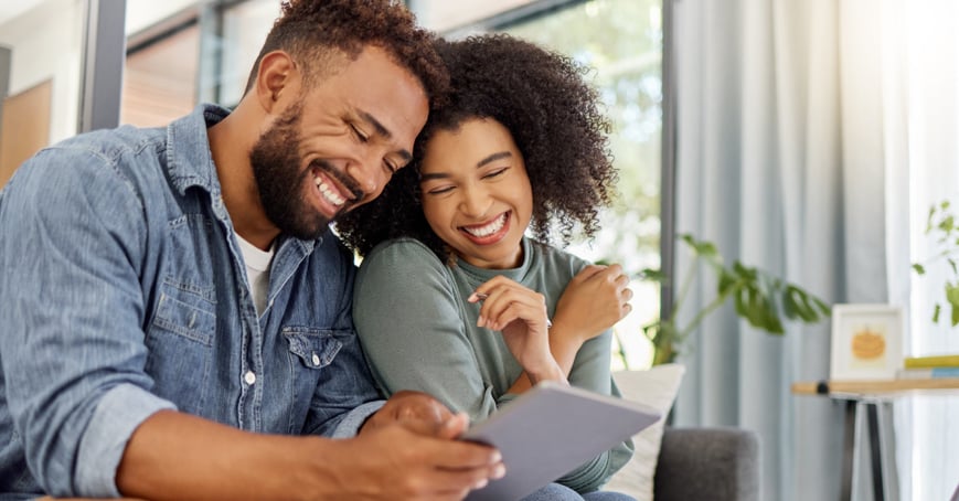 Couple looking at tablet, smiling together