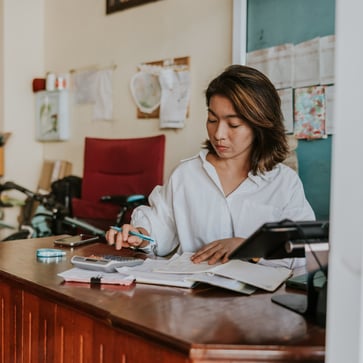 Small business owner calculating finances at her desk