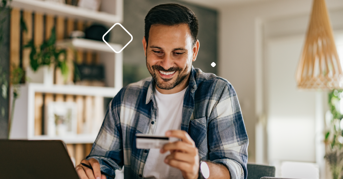 Man smiling with credit card in hand