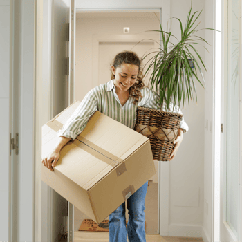 Woman carrying boxes out of home