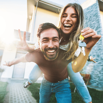 Couple holding keys in front of new home