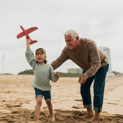 Empty nester playing at beach with grandchild