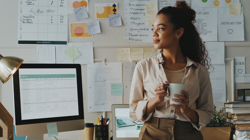 Woman standing at her desk thinking