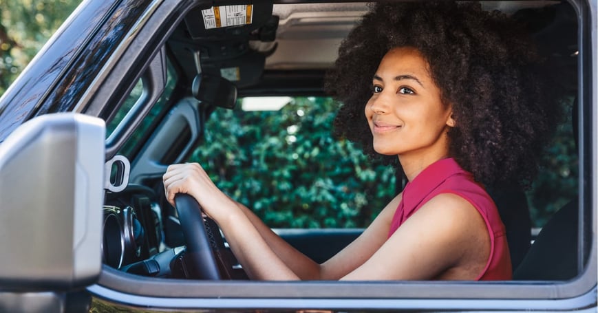Woman driving SUV looking off in the distance