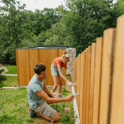 Couple repairing backyard fence