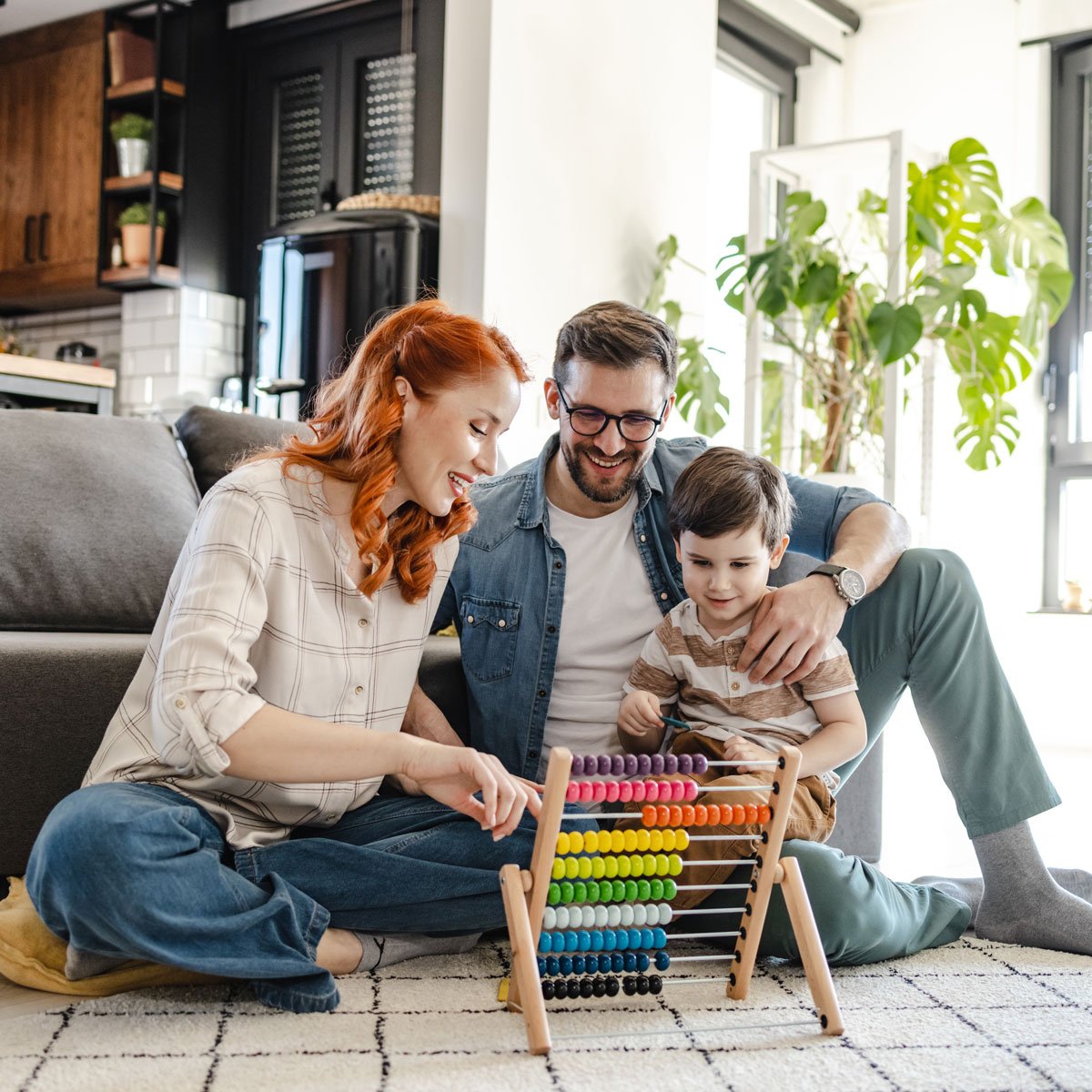 Family sitting on floor playing with toddlers' toy