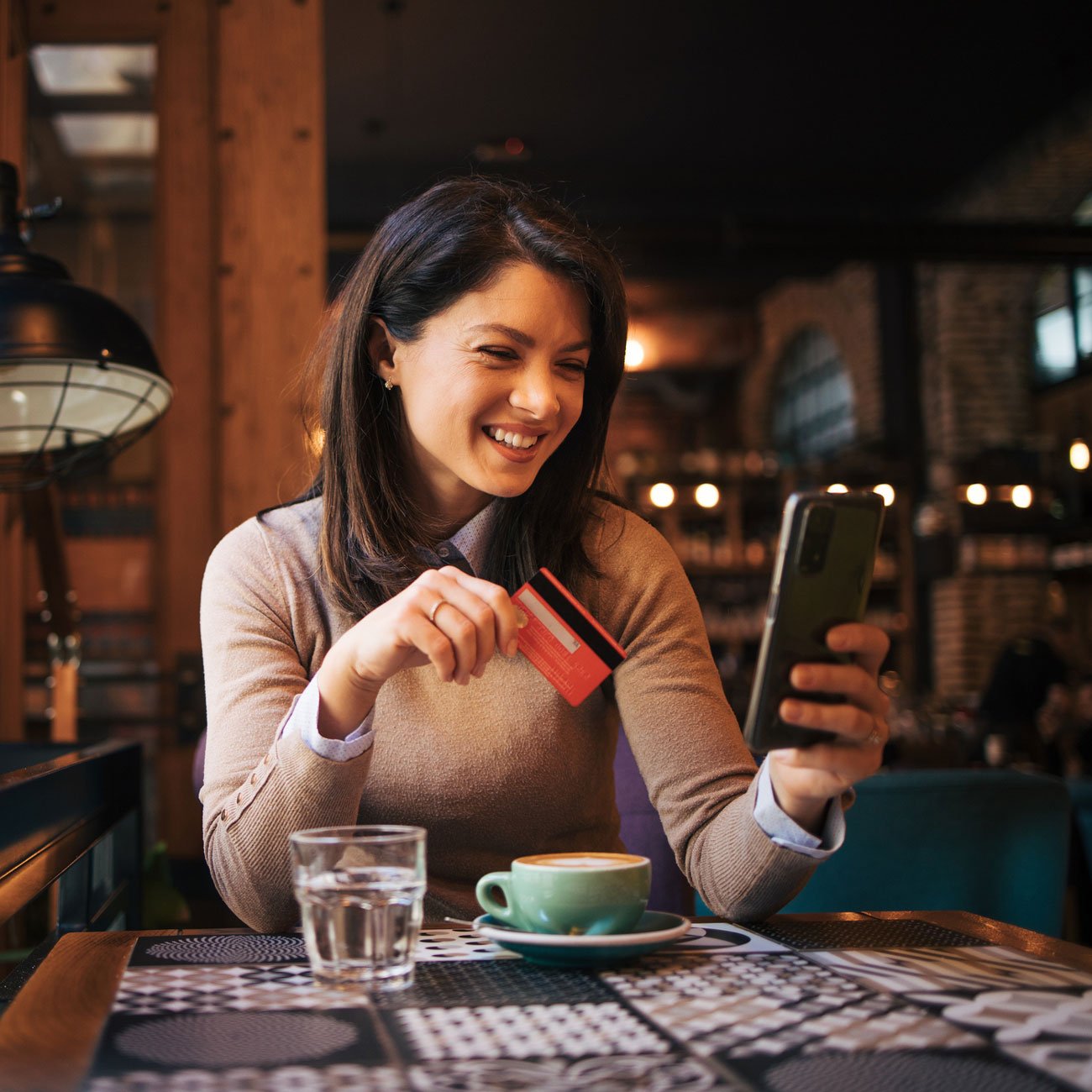 woman-using-credit-card-at-coffeeshop