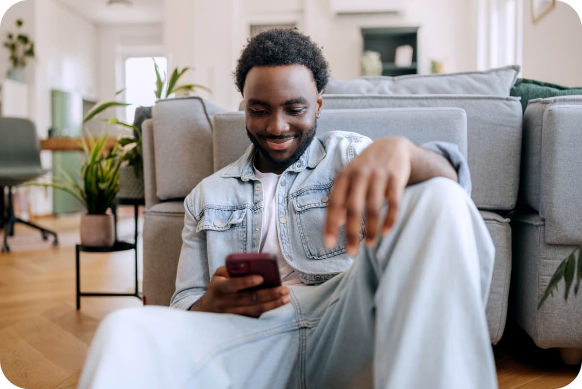 Man sitting on floor looking at phone