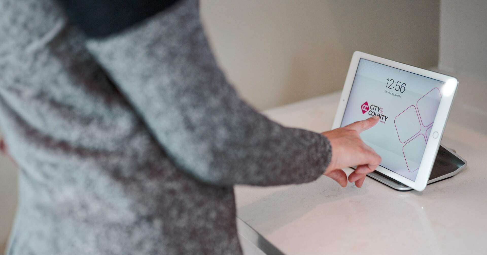 Person using tablet display in City & County Credit Union
