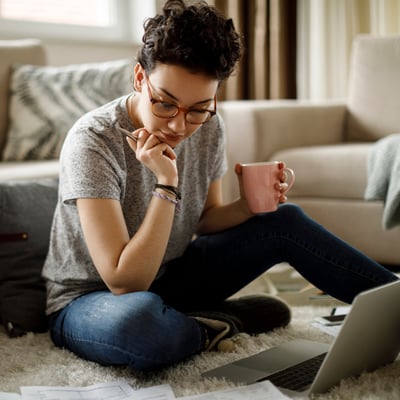 young woman building a budget on her laptop