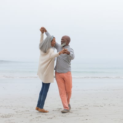 Retired couple dancing on the beach