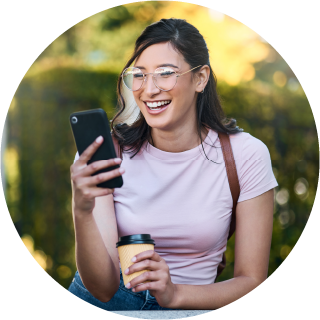 college student smiling while looking at cellphone