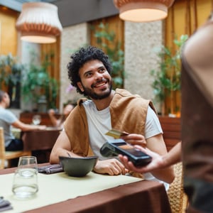 Man swiping credit card at restaurant