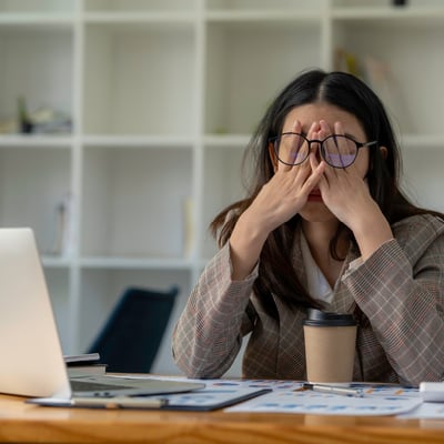 Woman stressed at computer by scammers