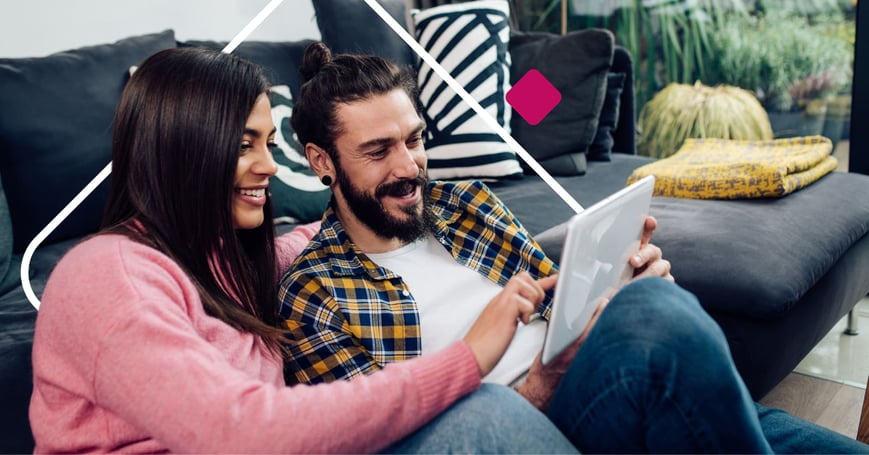 Couple sitting on floor looking at tablet