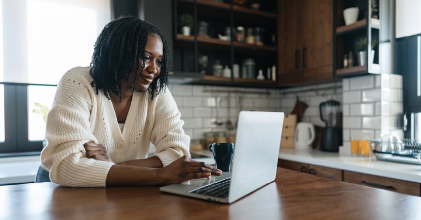 Woman sitting at counter calculating finances